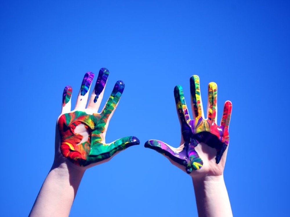 Hands covered in colourful paint
